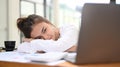 Bored female office employee tired from work, does not have inspiration for work, with head lying on her arm at office Royalty Free Stock Photo