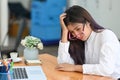 Bored female sitting at her workplace in the office. Royalty Free Stock Photo