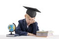 Bored first grader boy in students hat does his homework. Education concept. Tired schoolboy isolated on white background Royalty Free Stock Photo