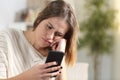 Bored girl holding smart phone at home Royalty Free Stock Photo