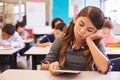 Bored girl reading tablet in elementary school class Royalty Free Stock Photo