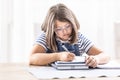 Bored girl writes homework into an exercise book Royalty Free Stock Photo