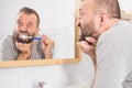 Bored guy brushing his teeth in bathroom Royalty Free Stock Photo