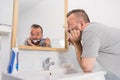 Bored guy brushing his teeth in bathroom Royalty Free Stock Photo