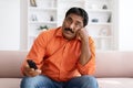 Bored Indian Man Watching TV Switching Channels With Remote Control Royalty Free Stock Photo
