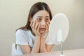 Bored, insomnia asian young woman, girl looking at mirror hand touching under eyes with problem of black circles or panda puffy, Royalty Free Stock Photo