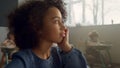 Bored kid sitting at desk in classroom. Thoughtful student looking at window Royalty Free Stock Photo