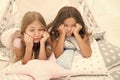 Bored kids on quarantine. Sisters best friends spend time together lay on pillows. Girls feeling sad. Girlish leisure