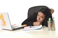 Bored latin businesswoman working tired at office computer desk looking exhausted