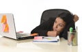 Bored latin businesswoman working tired at office computer desk looking exhausted