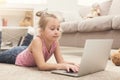 Bored little girl doing homework on laptop Royalty Free Stock Photo