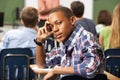 Bored Male Teenage Pupil In Classroom