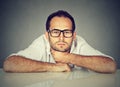 Bored man daydreaming showing no interest sitting at table