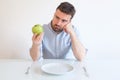 Sad and frustrated man on diet having only fruit for meal Royalty Free Stock Photo