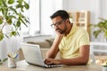 Bored man with laptop working at home office