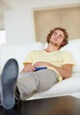 Bored man, remote control and watching tv on sofa with bad mood, chilling on streaming service in his home. Depression Royalty Free Stock Photo