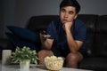 Bored man watching tv and sitting on sofa in the living room at Royalty Free Stock Photo