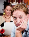 Bored man with woman on laptop computer Royalty Free Stock Photo