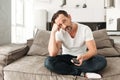 Bored mature man sitting on a sofa Royalty Free Stock Photo