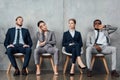 Bored multiethnic businesspeople sitting on chairs in Royalty Free Stock Photo