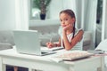 Disinterested tired little dissatisfied Afro-American girl sitting at the laptop