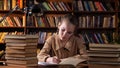 Bored schoolgirl looks into book and writes in copybook Royalty Free Stock Photo