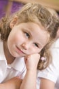 Bored schoolgirl sitting in primary class Royalty Free Stock Photo