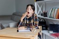 Bored secondary school girl yawning. Young learner tired of studying, reading books and classes Royalty Free Stock Photo