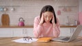 Bored sleepy asian lady sitting at desk with laptop, holding head, resting on hand, sleeping at workplace, tired young Royalty Free Stock Photo