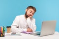 Bored sleepy man office worker napping sitting at workplace with laptop on desk leaning head on hand, feeling boredom, lazy to Royalty Free Stock Photo