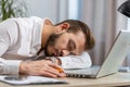 Bored sleepy business man worker working on laptop computer, yawning, falling asleep at home office Royalty Free Stock Photo