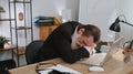 Bored sleepy business man worker working on laptop computer, yawning, falling asleep at office Royalty Free Stock Photo