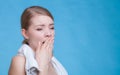 Bored sleepy woman yawning while holding towel