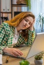 Bored sleepy businesswoman worker working on laptop computer leaning on hand at office desk