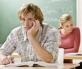 Bored student at desk in classroom Royalty Free Stock Photo