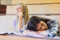 Bored student listening while classmate sleeping Royalty Free Stock Photo