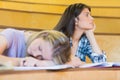 Bored student listening while classmate sleeping Royalty Free Stock Photo