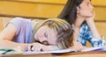 Bored student listening while classmate sleeping Royalty Free Stock Photo
