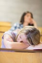 Bored student listening while classmate sleeping Royalty Free Stock Photo