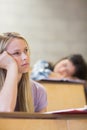 Bored student listening while classmate sleeping Royalty Free Stock Photo
