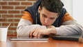 Bored student reading news tablet, young man sitting alone in cafe, depression Royalty Free Stock Photo