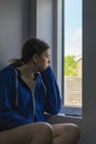 Bored teenage girl looking out of window Royalty Free Stock Photo