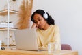 Bored and tired African-American female student watching online distance class on laptop Royalty Free Stock Photo