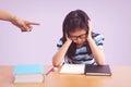 Bored and tired asian student girl doing homework. Angry mother pointing with him Royalty Free Stock Photo