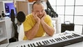 Bored, tired caucasian male musician, a sad, handsome portrait of a middle-aged pianist playing a somber song at a piano in an Royalty Free Stock Photo