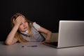 Bored and tired little girl sitting infront of the computer. Feeling sick and headache concept. Royalty Free Stock Photo