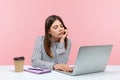 Bored unhappy business woman sitting at workplace looking at laptop display having video call, tired of online conference, Royalty Free Stock Photo