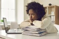 Tired bored young woman sitting at office desk and waiting for working day to end Royalty Free Stock Photo