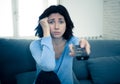 Bored woman changing TV channels with remote control