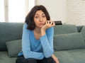 Bored woman changing TV channels with remote control